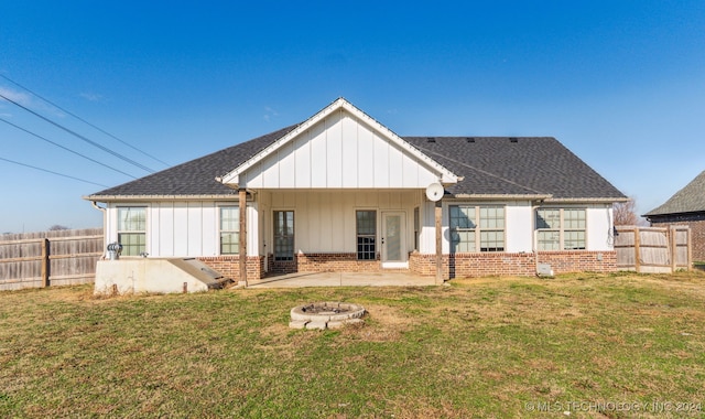 back of house featuring a yard, a fire pit, and a patio area