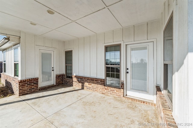 view of exterior entry with a patio area