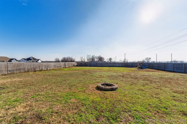 view of yard with a playground and an outdoor fire pit