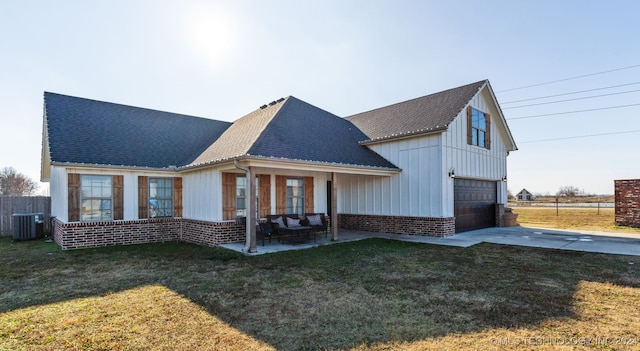 rear view of property featuring central AC, a yard, and a garage