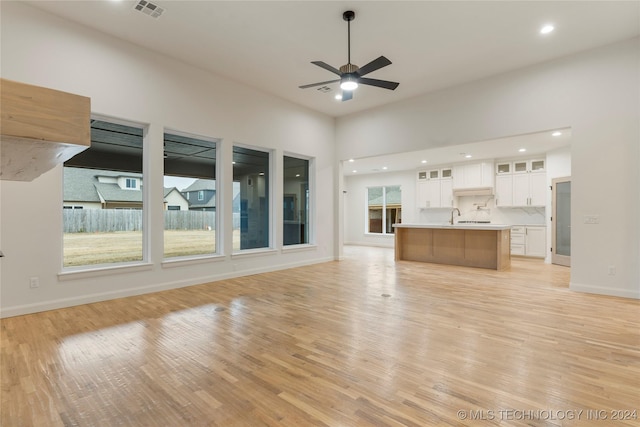 unfurnished living room featuring ceiling fan and light hardwood / wood-style flooring