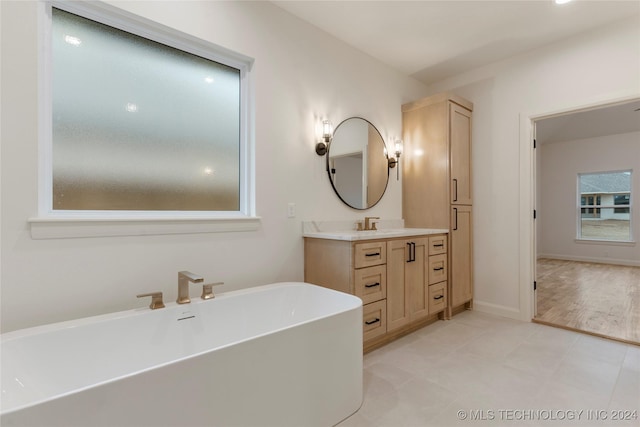 bathroom featuring vanity and a bath