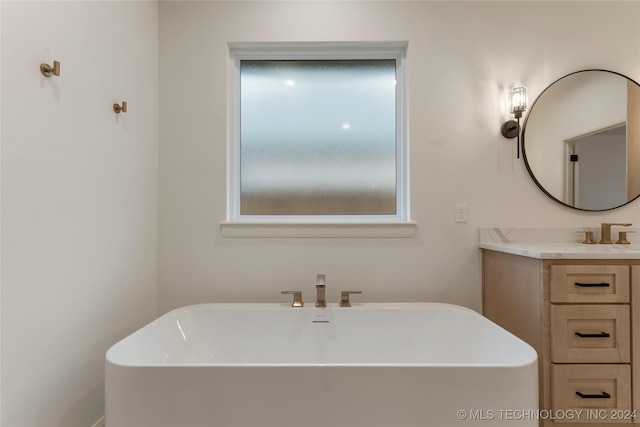 bathroom featuring vanity and a tub to relax in