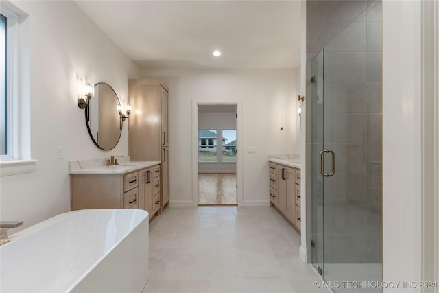 bathroom featuring vanity, separate shower and tub, and a wealth of natural light