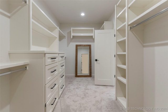 walk in closet featuring light carpet