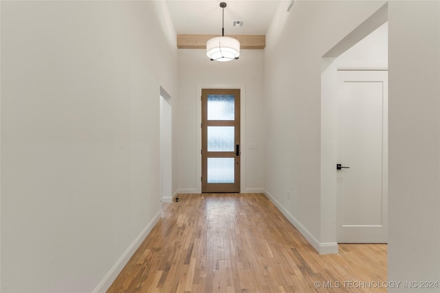 doorway with beam ceiling and light hardwood / wood-style floors