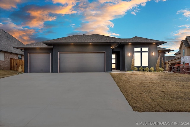 prairie-style house featuring a lawn and a garage