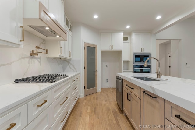 kitchen with backsplash, light stone countertops, sink, and white cabinets