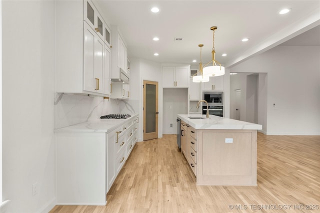 kitchen featuring recessed lighting, light wood finished floors, appliances with stainless steel finishes, and a sink