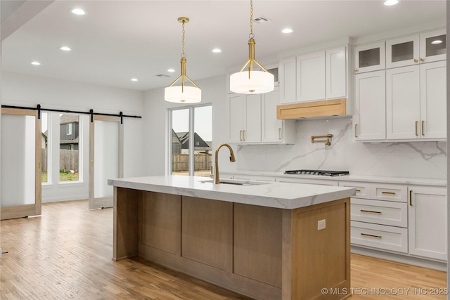 kitchen with a sink, recessed lighting, and a barn door