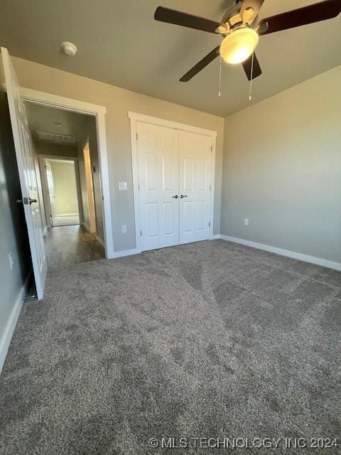 unfurnished bedroom with a closet, dark carpet, and ceiling fan