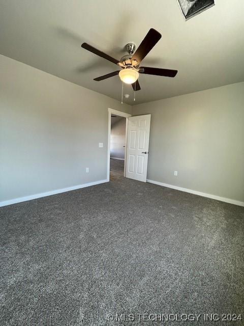 unfurnished bedroom featuring dark colored carpet and ceiling fan