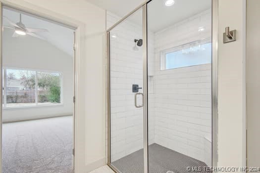 bathroom with ceiling fan and an enclosed shower