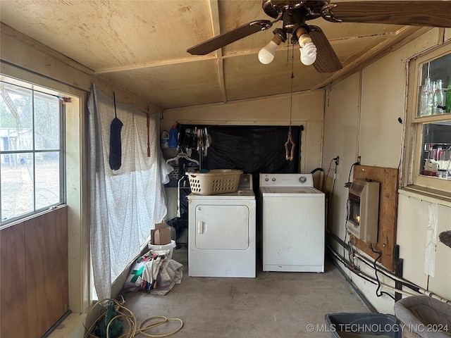 washroom with washing machine and clothes dryer, heating unit, ceiling fan, and a healthy amount of sunlight