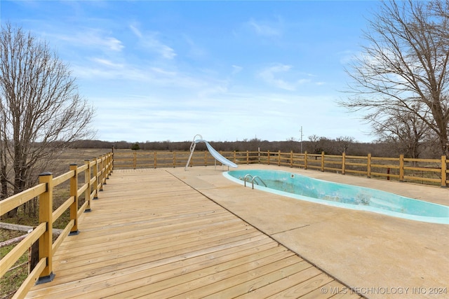 view of pool with a rural view, a patio, and a water slide