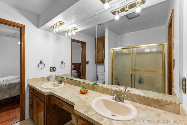 bathroom with vanity, a shower with shower door, and toilet