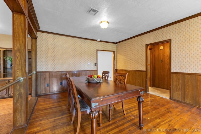 dining room featuring a textured ceiling, crown molding, and dark hardwood / wood-style floors