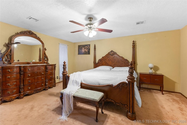 carpeted bedroom featuring ceiling fan and a textured ceiling