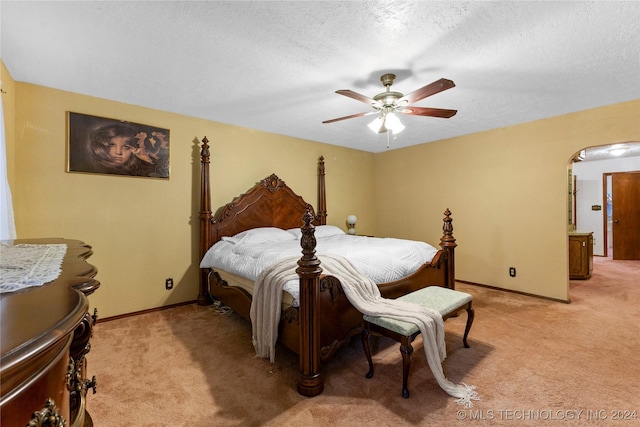 carpeted bedroom with ceiling fan and a textured ceiling