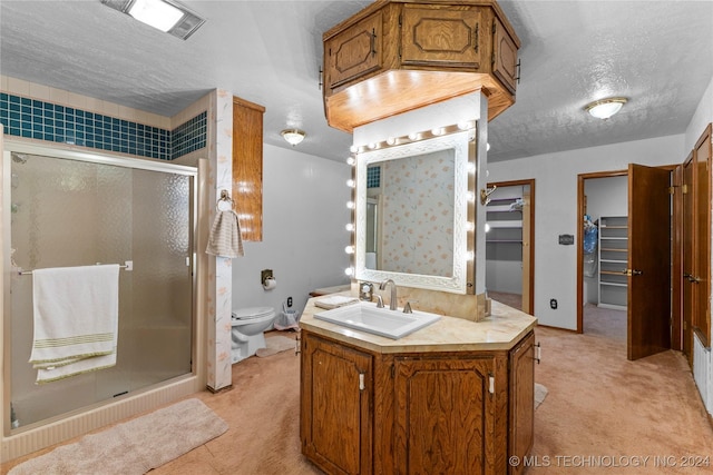 bathroom featuring a textured ceiling, vanity, toilet, and walk in shower