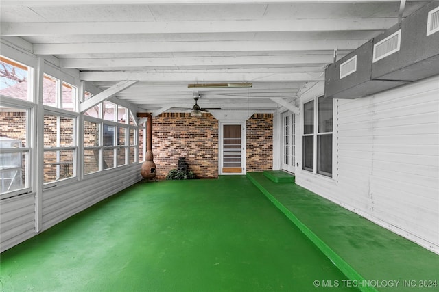 unfurnished sunroom featuring beam ceiling