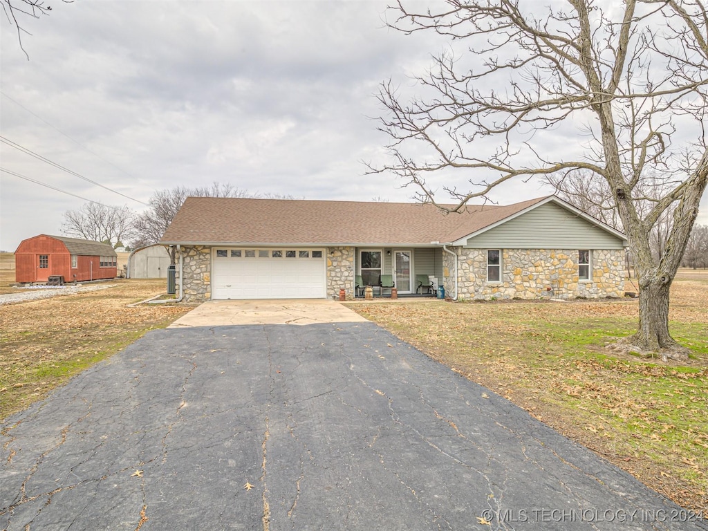 ranch-style home featuring a garage and a front lawn