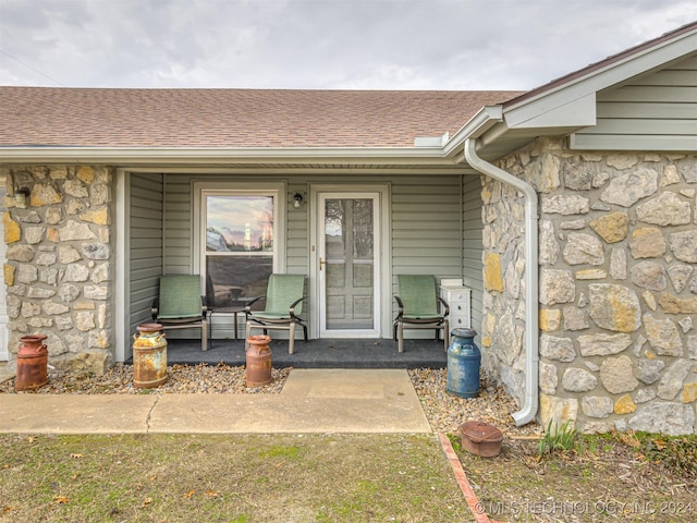 view of exterior entry featuring covered porch