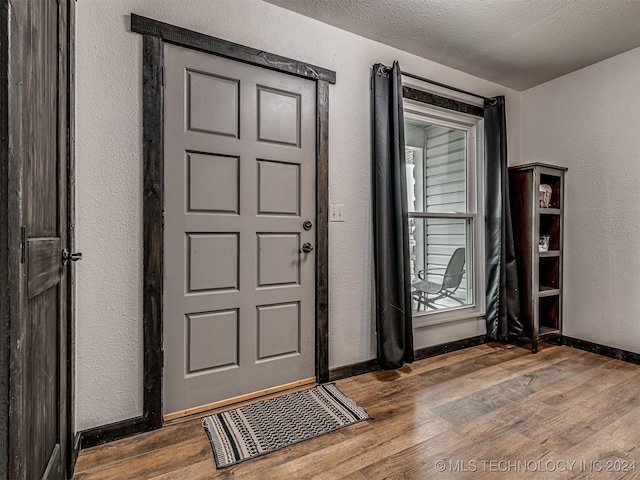 entrance foyer with a textured ceiling and dark hardwood / wood-style floors