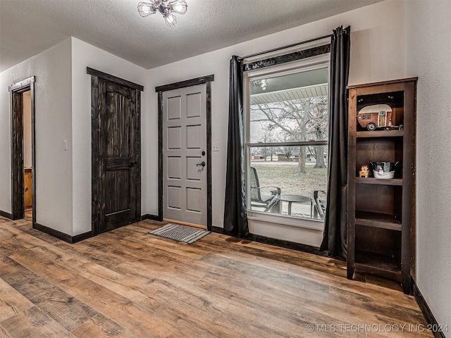 foyer entrance with wood-type flooring and a textured ceiling