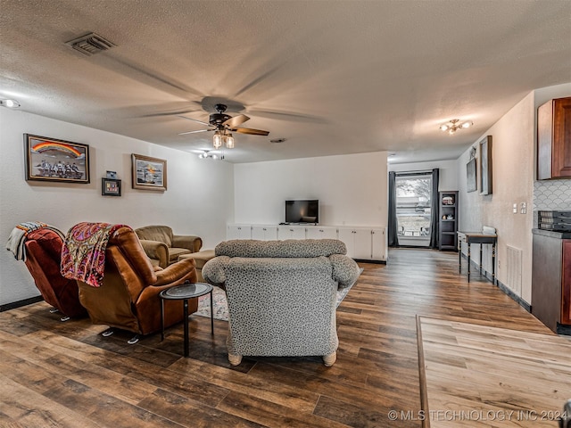 living room with wood-type flooring, a textured ceiling, and ceiling fan