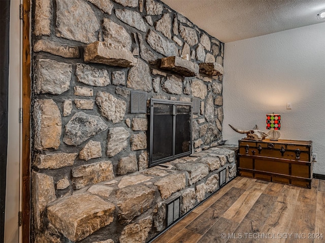 living room featuring hardwood / wood-style flooring, a fireplace, and a textured ceiling