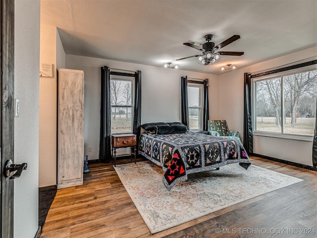 bedroom featuring hardwood / wood-style floors, ceiling fan, and a textured ceiling