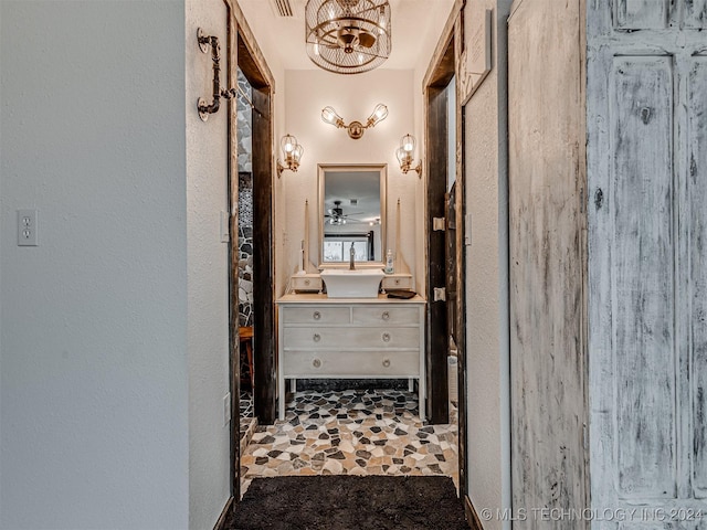 hall featuring a chandelier and sink