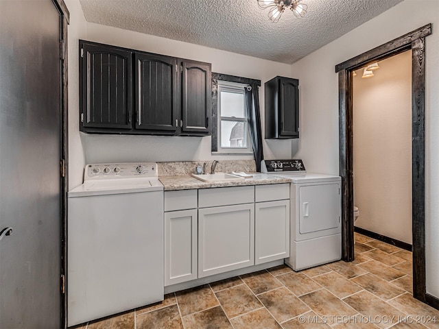 laundry area featuring a textured ceiling, cabinets, sink, and washer / clothes dryer