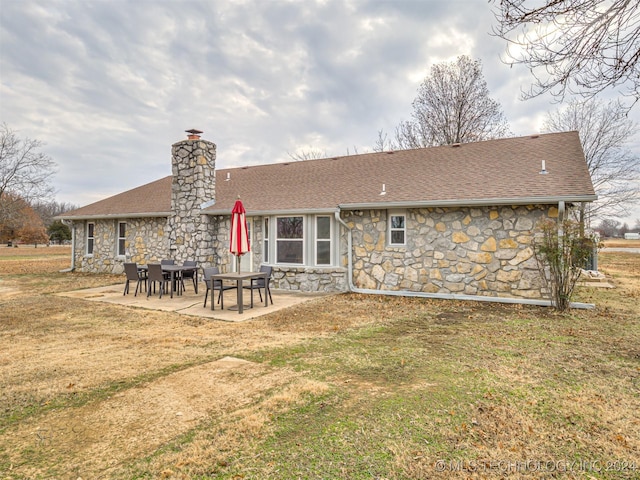 rear view of house with a lawn and a patio