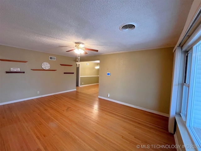 empty room with ceiling fan, a textured ceiling, and light hardwood / wood-style flooring