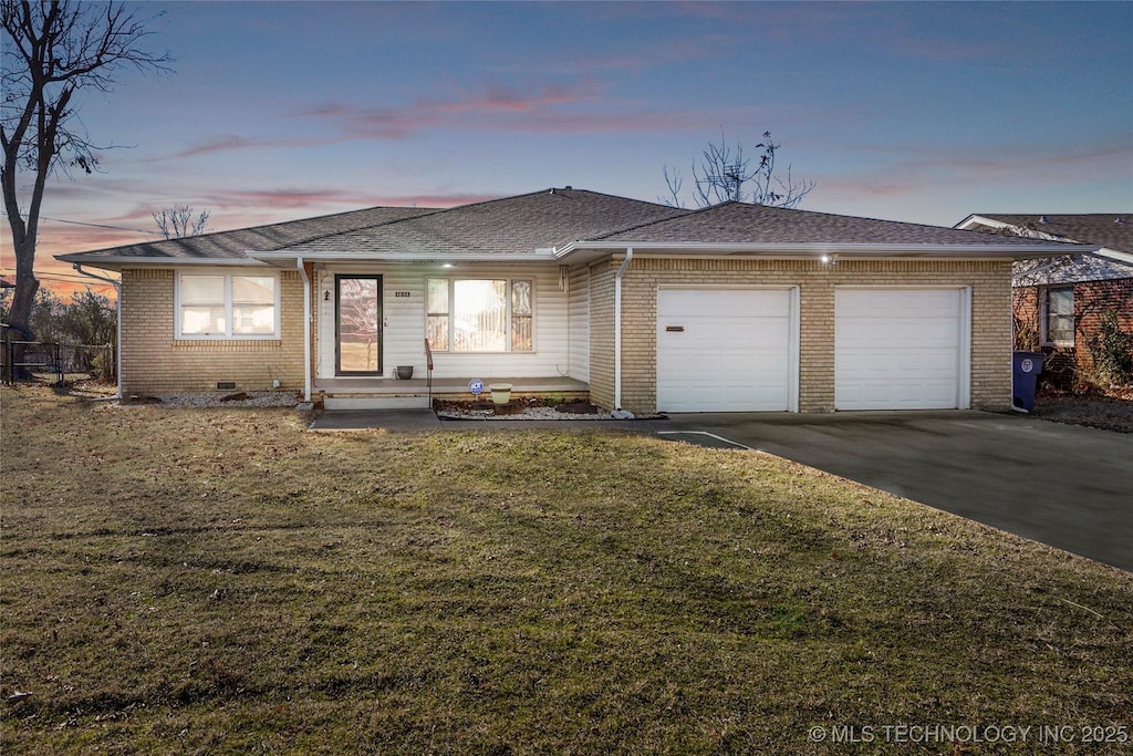 view of front of property featuring a garage and a lawn