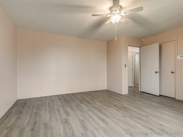 unfurnished bedroom featuring ceiling fan, a textured ceiling, and light wood-type flooring