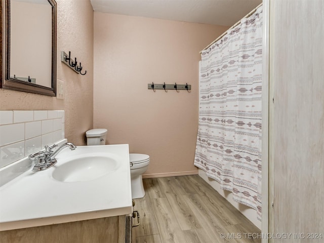 bathroom with hardwood / wood-style floors, vanity, and toilet