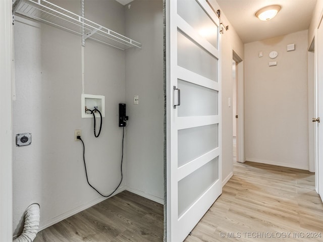 clothes washing area featuring hookup for an electric dryer, hookup for a washing machine, and light hardwood / wood-style flooring