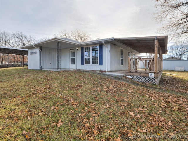 view of front of home with a front yard and a carport