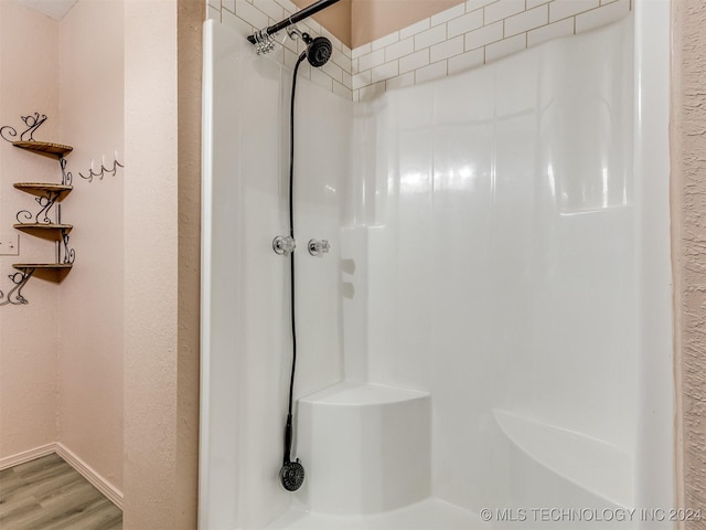 bathroom with hardwood / wood-style floors and walk in shower