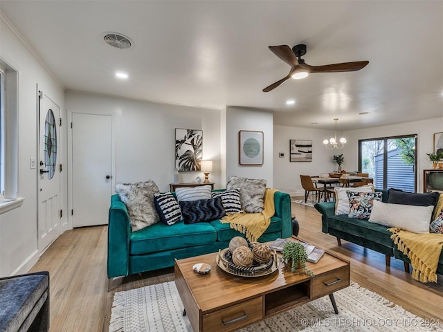 living room featuring ceiling fan with notable chandelier, light wood-style flooring, visible vents, and recessed lighting