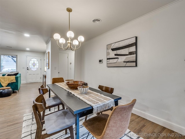 dining space with baseboards, ornamental molding, visible vents, and light wood-style floors