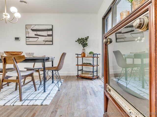 office featuring an inviting chandelier, baseboards, crown molding, and wood finished floors