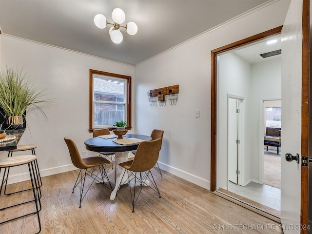 dining area with light wood-type flooring, baseboards, visible vents, and ornamental molding