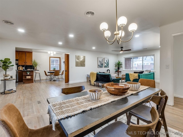 dining space with light wood-type flooring, visible vents, and recessed lighting