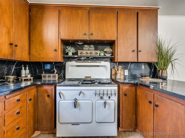 kitchen with range with two ovens, brown cabinetry, and tasteful backsplash