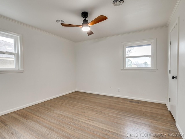 unfurnished room with light wood finished floors, baseboards, visible vents, and crown molding