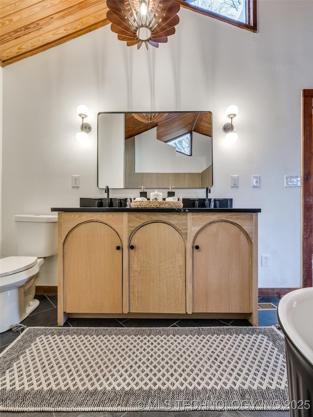 full bathroom with double vanity, toilet, tile patterned floors, high vaulted ceiling, and a sink